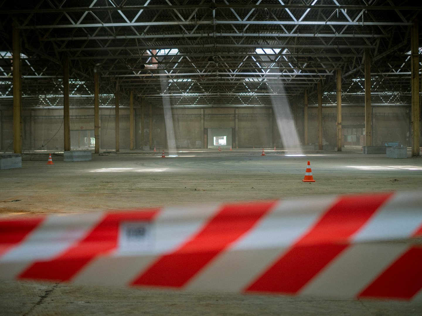 Empty warehouse with sunbeams through the roof.